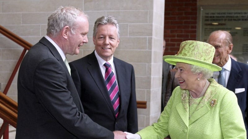 In what was seen as a significant act of reconciliation, Queen Elizabeth and deputy first minister Martin McGuinness shook hands in Belfast in 2012, with first minister Peter Robinson looking on. Photo: Paul Faith/PA Wire. 