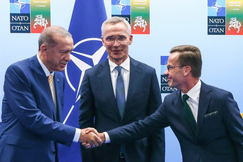 Turkey’s President Recep Tayyip Erdogan, left, shakes hands with Sweden’s Prime Minister Ulf Kristersson, right, as Nato secretary general Jens Stoltenberg looks on (Yves Herman, Pool Photo via AP, File)
