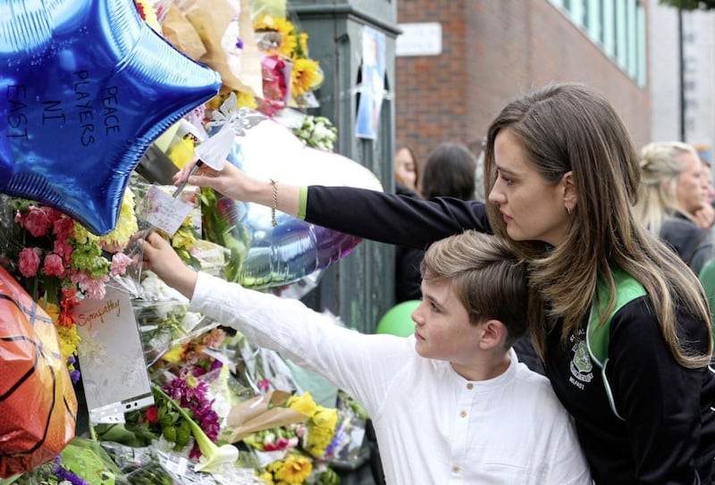 Placing floral tributes on the gates of St Malachy&#39;s College after the funeral of teenager Noah Donohoe. Picture by Mal McCann 