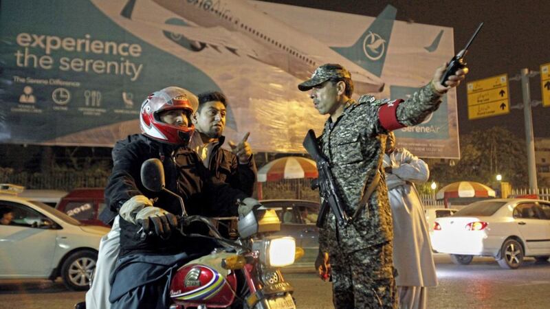 An airport security officer directs a motorcyclist at the entrance to the Benazir Bhutto International Airport in Islamabad, Pakistan Picture by Anjum Naveed/AP 