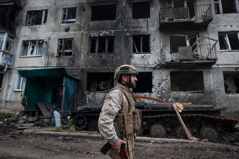 A Ukrainian soldier passes by a damaged apartment building in Chasiv Yar, the site of heavy battles with the Russian forces in Ukraine’s Donetsk region (Iryna Rybakova via AP)
