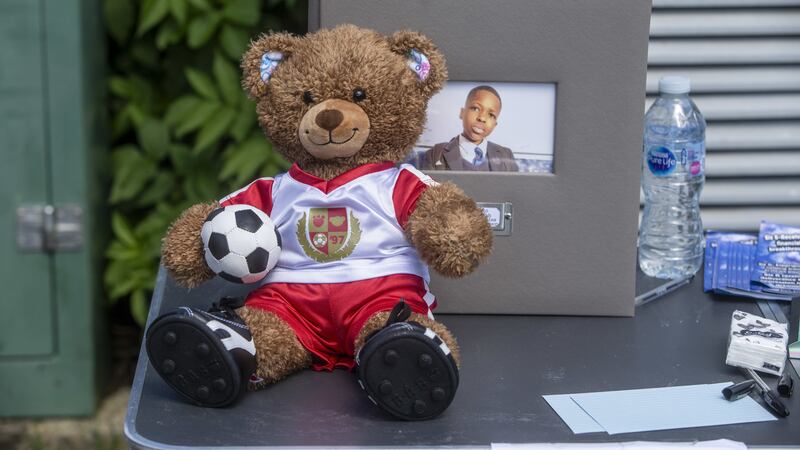 A teddy bear in an Arsenal top on a table at vigil in Hainault