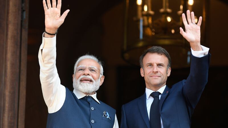 French President Emmanuel Macron and India’s Prime Minister Narendra Modi wave before attending a meeting at the Foreign Affairs ministry in Paris (Julien de Rosa, Pool via AP/PA)