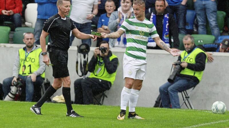 Celtic striker Leigh Griffiths shows the referee a glass bottle thrown onto the pitch at Windsor Park during Friday's game with Linfield. Picture by Matt Bohill