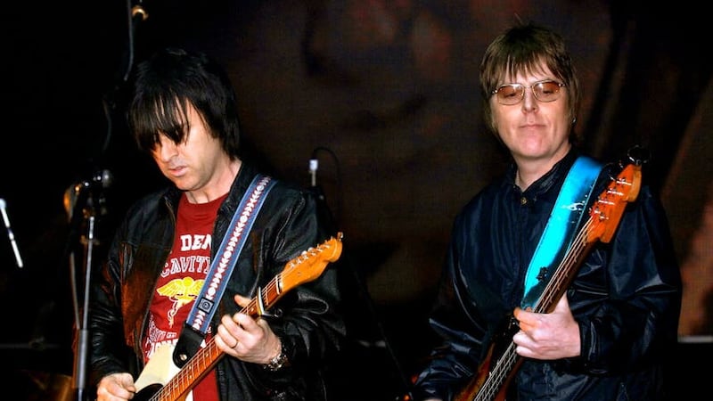 Andy Rourke, right, and Johnny Marr on stage together concert (PA)