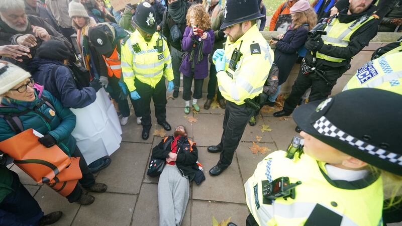 Police officers remove a Just Stop Oil protester outside New Scotland Yard in London on Saturday (Yui Mok/PA)
