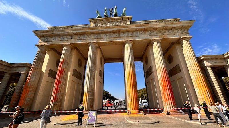 Members of the climate protection group Last Generation have sprayed the Brandenburg Gate with orange paint (Paul Zinken/dpa via AP)