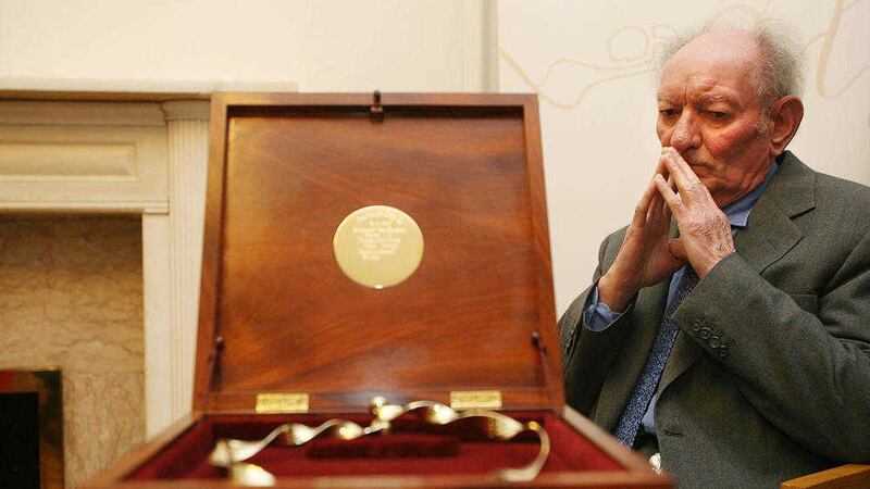 Playwright Brian Friel looks at the Golden Torc he received from Aosd&aacute;na in 2006. Picture by Julien Behal, Press Association 