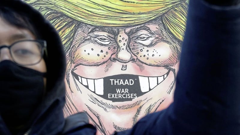 A South Korean protester stands in front of a cartoon depicting president Donald Trump during a rally against US defence secretary Jim Mattis&#39;s visit, in front of the government complex in Seoul, South Korea, Thursday Feb 2 2017. Picture by Ahn Young-joon, Associated Press 