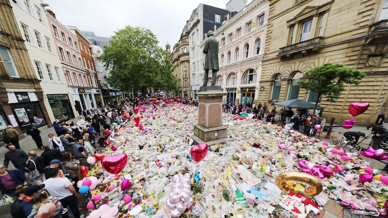 People look at flowers and tributes left in St Ann’s Square in Manchester after the attack in 2017