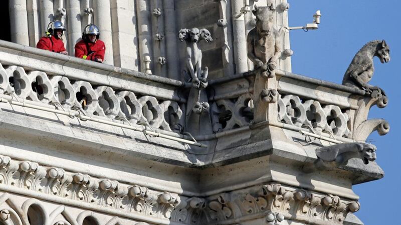 Fire fighters wait at a balcony of Notre Dame Cathedral on Wednesday, April 17 2019 in Paris. Nearly &euro;1 billion has already poured in from ordinary worshippers and high-powered magnates around the world to restore the cathedral after a massive fire Picture by Francois Mori/AP 