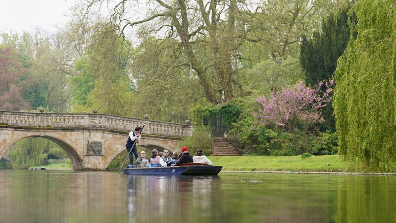 People enjoy a punt tour along the River Cam in Cambridge