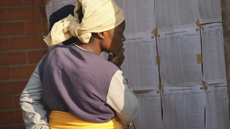 A woman looks for her name, outside a polling station in Harare (AP Photo/Tsvangirayi Mukwazhi)