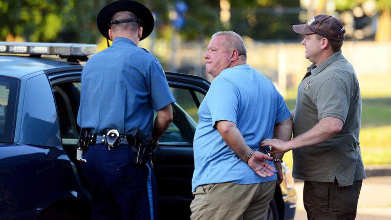 Francesco Depergola (60) of Springfield, is led to the Massachusetts State Police barracks in Springfield for booking following his arrest. Picture by Greg Saulmon, The Republican 