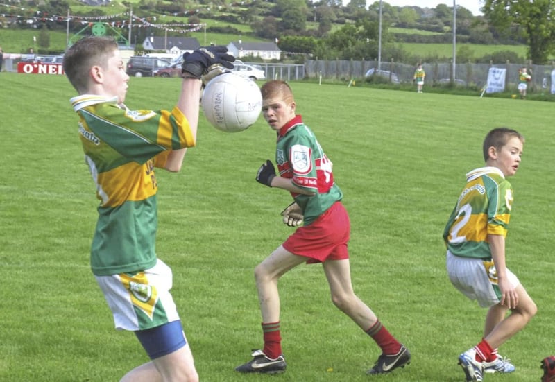 Cathal McShane (centre) keeping his eye on the ball against Aghyaran U13s 