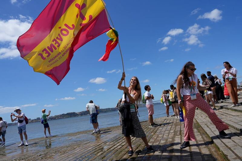 Pilgrim in the water waves a Spanish flag