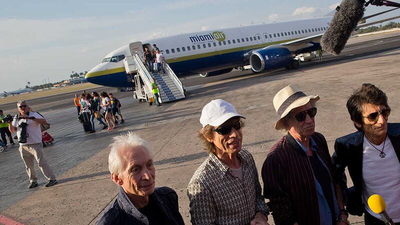 Members of The Rolling Stones, from left, Mick Jagger, Charlie Watts, Keith Richards and Ronnie Wood pose for photos from the plane that brought them to Cuba at Jose Marti international airport in Havana, Cuba&nbsp;
