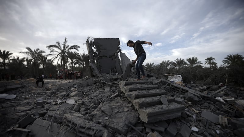 Palestinians inspect the damage of a destroyed house following Israeli airstrikes in the town of Khan Younis (AP)