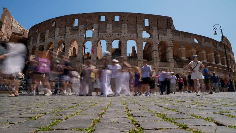 Visitors walk past the Colosseum, in Rome where a visitor was spotted carving their name (AP Photo/Andrew Medichini)