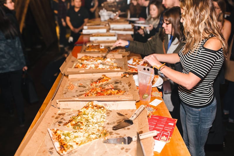 People eat pizza at a pizza party