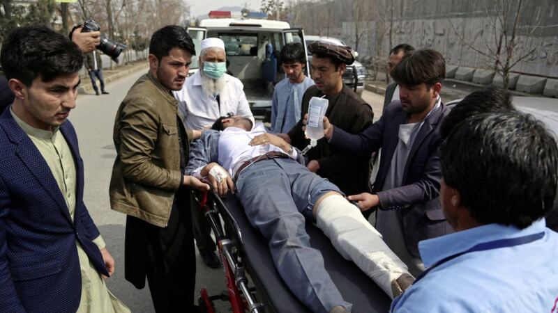 An injured man is carried into an ambulance after an attack in Afghanistan&#39;s capital Kabul on Friday. Picture by Rahmat Gul/AP 