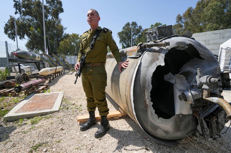 Israeli military spokesperson, Rear Adm Daniel Hagari, with one of the Iranian ballistic missiles Israel intercepted over the weekend (AP)