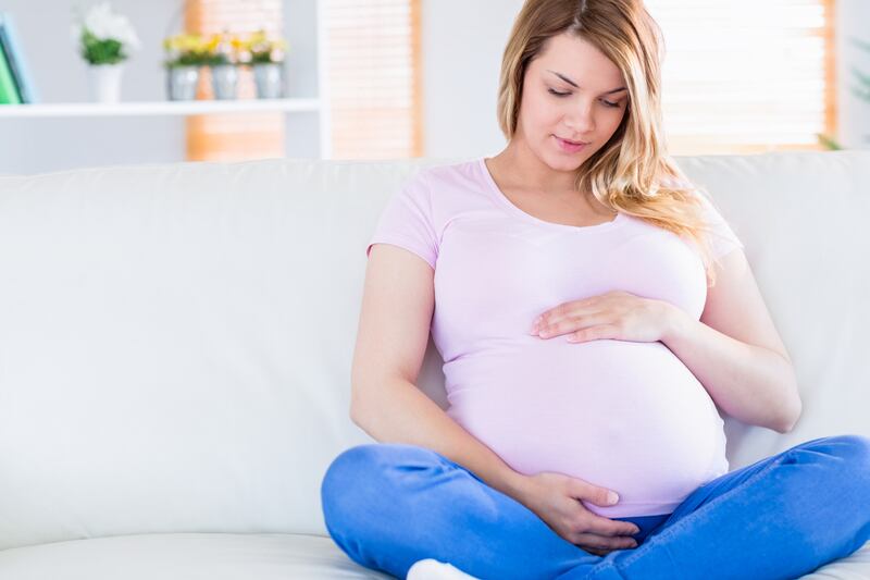 Pregnant woman looking at her bump