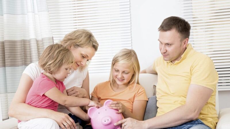 Family Saving Money In Piggybank At Home. 