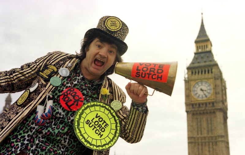 Screaming Lord Sutch, the former rock singer who brought zany humour to British politics with his Monster Raving Loony Party, posing for a photo in front of Big Ben in London