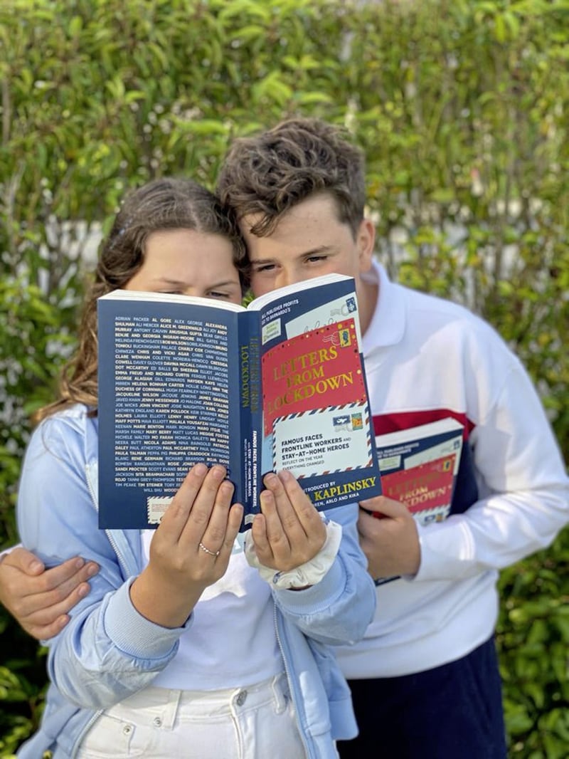 Kika and Arlo Kaplinsky behind the cover of their mother Natasha Kaplinski&#39;s book, Letters From Lockdown. The children wrote to friends, neighbours and celebrities during the pandemic 