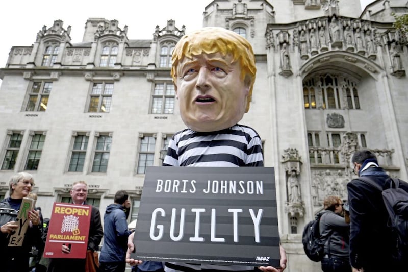A man wearing a giant Boris Johnson mask, dressed as a prisoner, outside the Supreme Court in London: Jonathan Brady/PA Wire. 