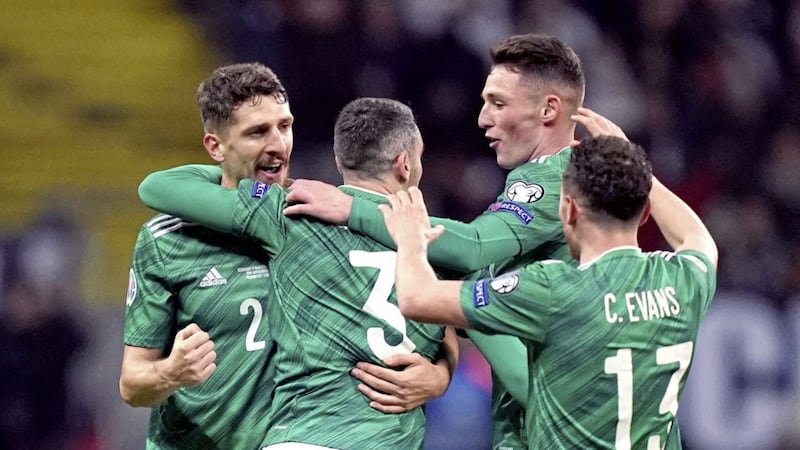 Michael Smith (wearing number three) is congratulated by team-mates after opening the scoring away to Germany on Wednesday night.