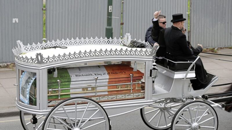 Paddy Doherty gives a thumbs up on a horse drawn hearse carrying the coffin of his father Simon Doherty along Harrow Road, en route to St Margaret&#39;s Catholic Cemetery, London PICTURE: Yui Mok/PA 