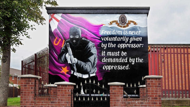 A mural of footballer George Best at Inverwood Court was replaced in 2013 by a painting of a UVF gunman. Picture by Cliff Donaldson 
