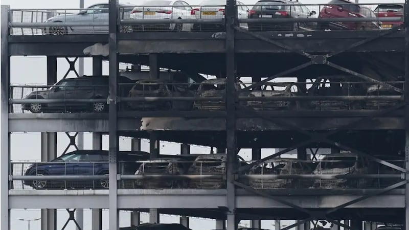 The burned-out shells of cars, buried among debris of a multi-storey car park at Luton Airport, Wednesday, after fire ripped through the structure