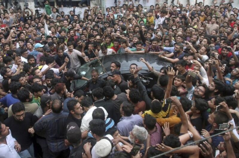Pakistani police officers try to make way for a car carrying cricket team's skipper Sarfraz Ahmed