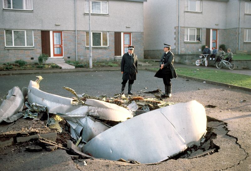 Police officers stand among debris after the explosion