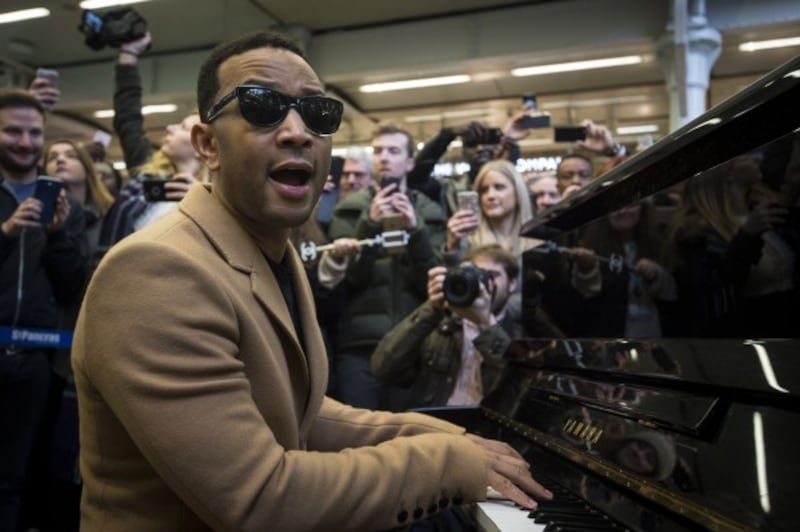 US singer John Legend plays the Elton John piano at St Pancras Station, London.