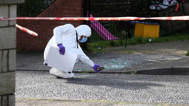 Forensics investigators examine the scene in Rossnareen Avenue following the shooting of Martin Gavin