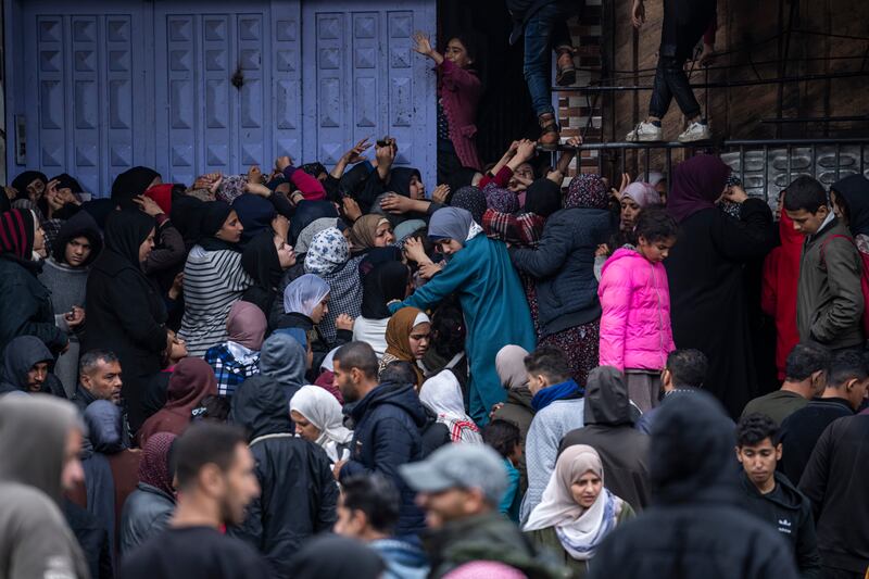 Palestinian crowds struggle to buy bread from a bakery in Rafah (Fatima Shbair/AP)