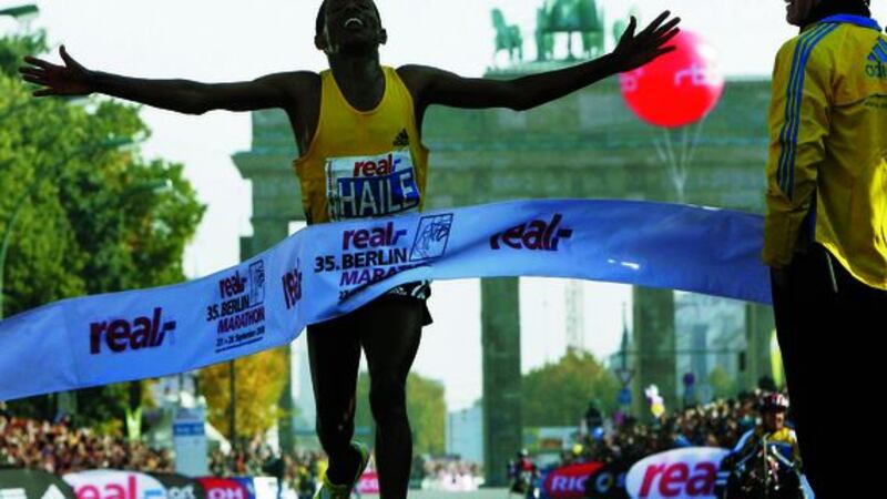 Haile Gebrselassie from Ethiopia crosses the finish line to win the 35th Berlin Marathon in Berlin in Germany Sunday Sept. 28 2008 breaking the marathon world record in 2 hours 3 minutes 59 seconds. In background is the landmark Brandenburg Gate. At right stands Germany's national soccer coach Joachim Loew. (AP Photo/Michael Sohn)&nbsp;