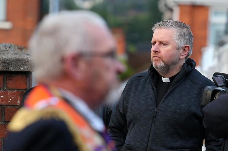 Fr Gary Donegan looked on as Orange Order members march through Ardoyne earlier this month 