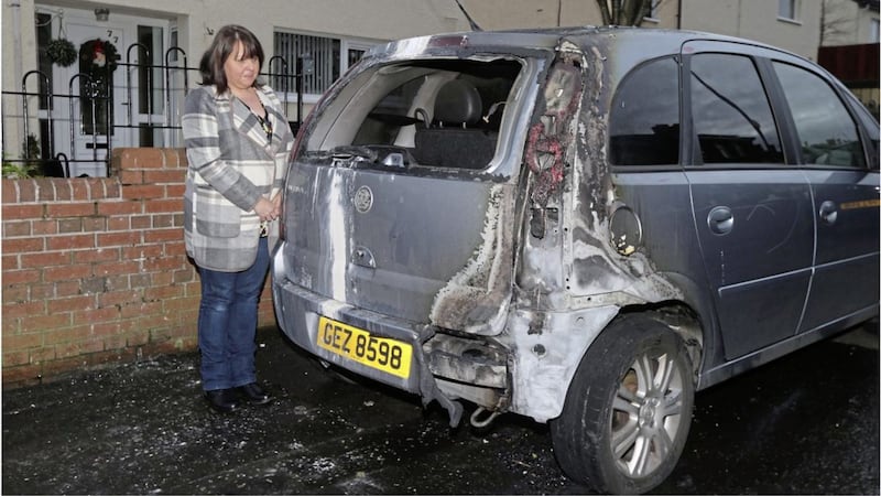 Jacqueline McCann with her car at Farringdon Gardens in Ardoyne after it was set on fire. Picture by Hugh Russell 