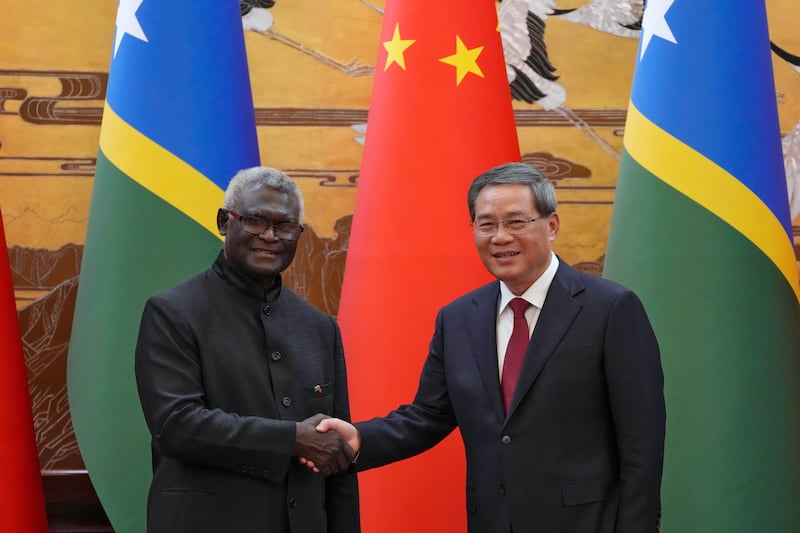 Solomon Islands Prime Minister Manasseh Sogavare, left, shakes hands with his Chinese counterpart, Li Qiang, in Beijing in July 2023 (Andy Wong/Pool/AP)