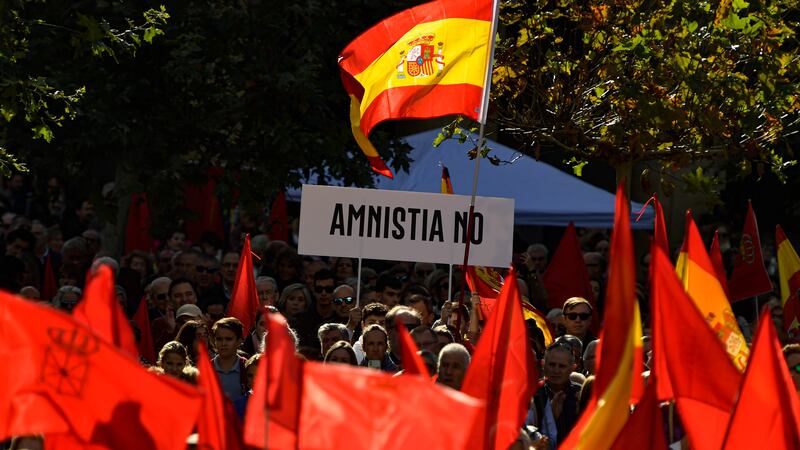 Demonstrators hold up a banner reading ‘No to Amnesty’ as people wave Spanish and Navarre flags during a protest against the potential amnesty law, in Pamplona, northern Spain (Alvaro Barrientos/AP)