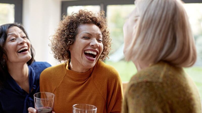 Group Of Mature Female Friends Meeting At Home To Talk And Drink Wine Together 