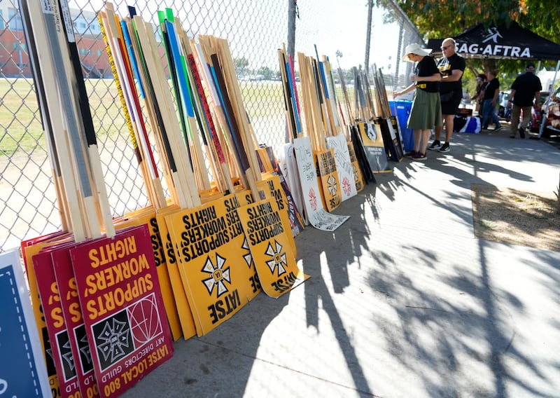 Striking Sag-Aftra members choose signs for a picket line outside Netflix studios in Los Angeles 