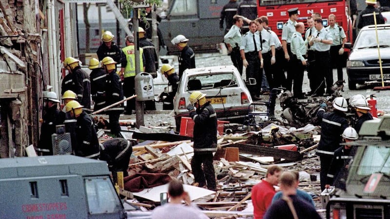 Police officers and firefighters inspecting the damage caused by a bomb explosion in Market Street, Omagh. 