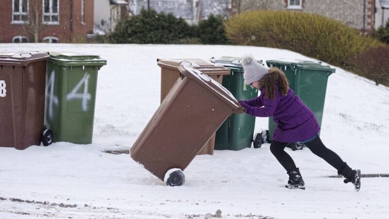 A girl struggles to bring in her bin in Lisburn. Picture by Mark Marlow 