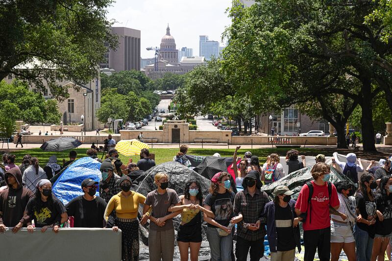 Protesters link arms at an encampment at the University of Texas at Austin (Aaron E Martinez/Austin American-Statesman via AP)